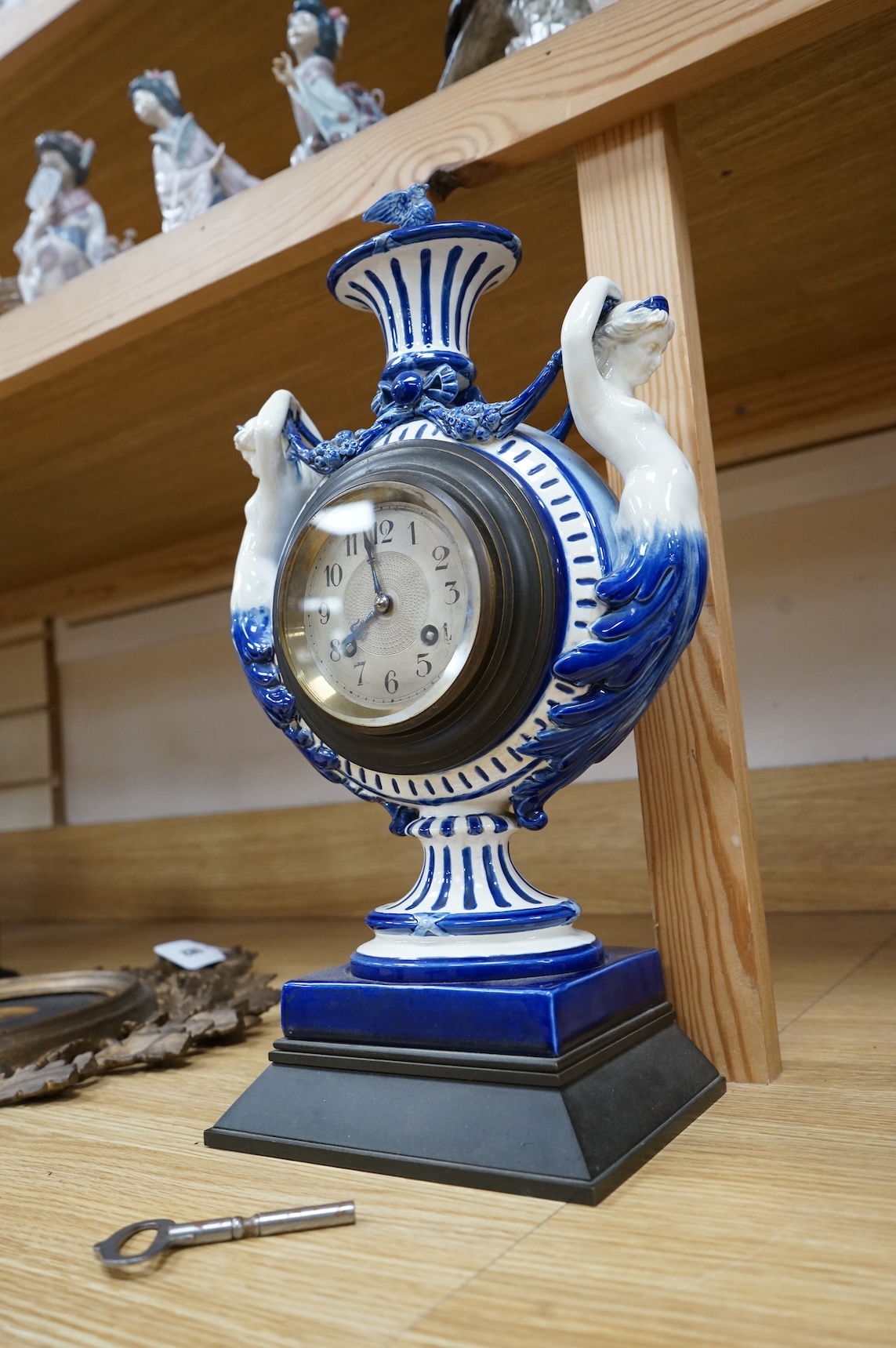An early 20th century figural glazed ceramic mantle clock, 21cm wide x 40cm high